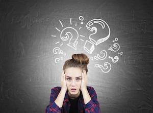 Woman surrounded by question marks trying to make a decision